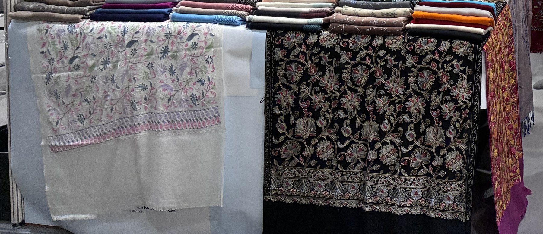 Close-up field photograph of handmade textile shawls exhibited in Hong Kong